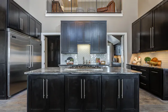 a kitchen with stainless steel appliances granite countertop a refrigerator and a stove