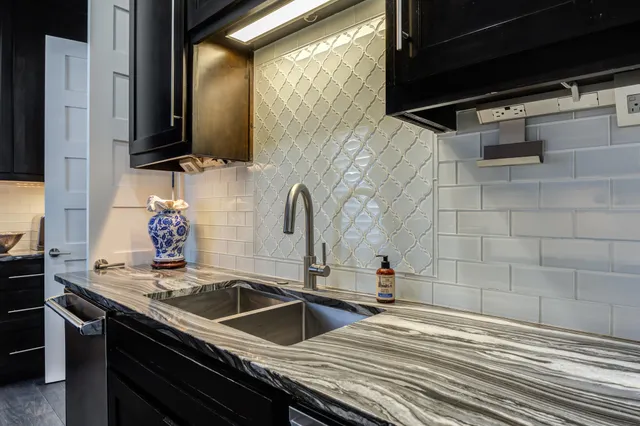 a bathroom with a granite countertop sink a mirror and a bathtub