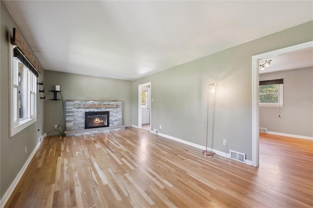 2521 Hopkins Church Road Sewickley, PA 15143 - Photo 7 of 34 an empty room with wooden floor fireplace and windows