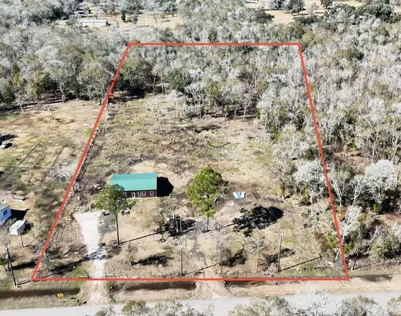 a view of a dry yard with wooden fence
