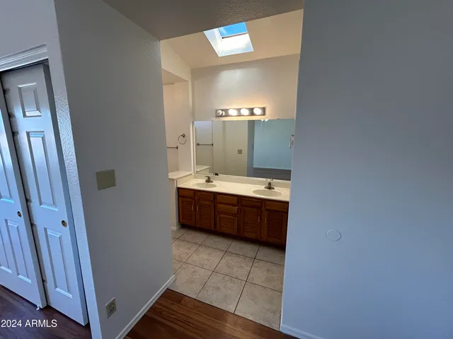 a large bathroom with a double vanity sink toilet mirror and bathtub