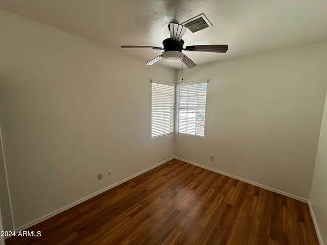 an empty room with a window and a ceiling fan