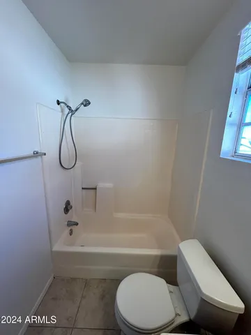 a bathroom with a toilet and a bath tub