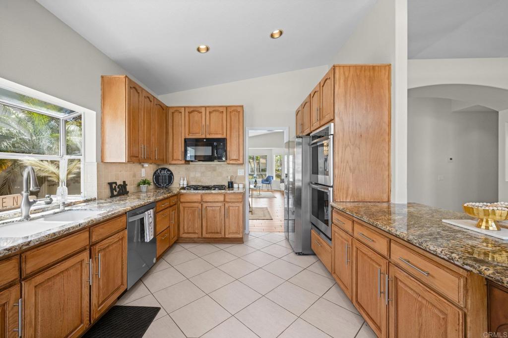 342 Benevente Drive Oceanside, CA 92057 - Photo 13 of 43 a large kitchen with granite countertop a sink stainless steel appliances and cabinets