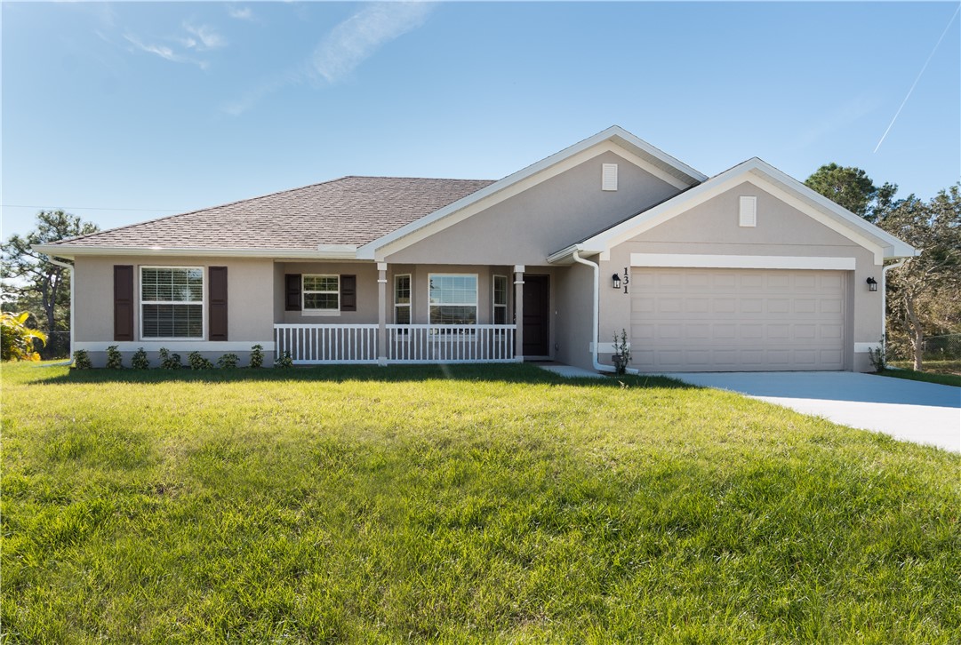a front view of a house with yard and garage