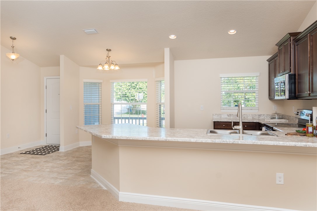 1361 Seahouse Street Sebastian, FL 32958 - Photo 2 of 13 a kitchen with stainless steel appliances granite countertop a sink a stove and a refrigerator
