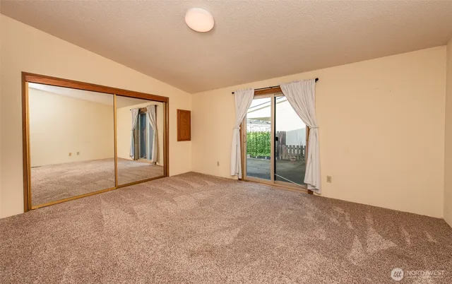 an empty room with sliding glass door and shower