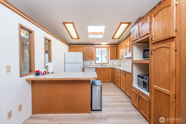 a kitchen with stainless steel appliances granite countertop a lot of cabinets and wooden floor