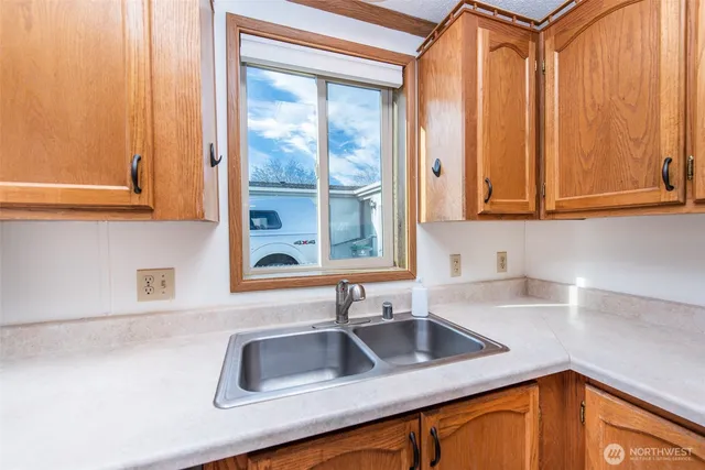 a kitchen with stainless steel appliances granite countertop a sink and a window