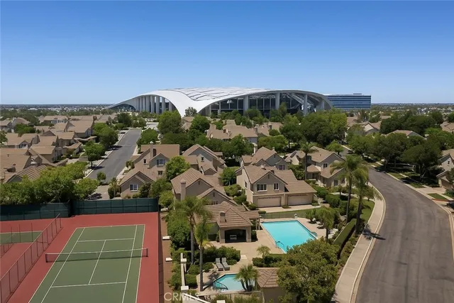 an aerial view of a tennis ground and a houses