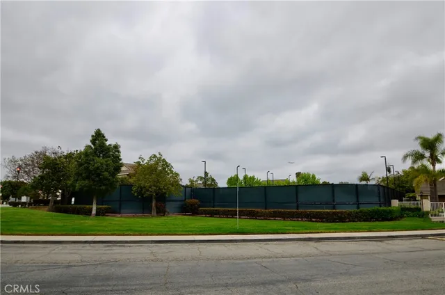 a green field with lots of trees in the background