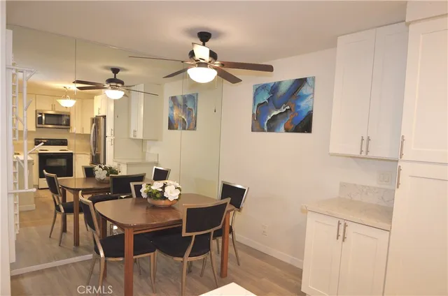 a view of a dining room with furniture and a chandelier fan