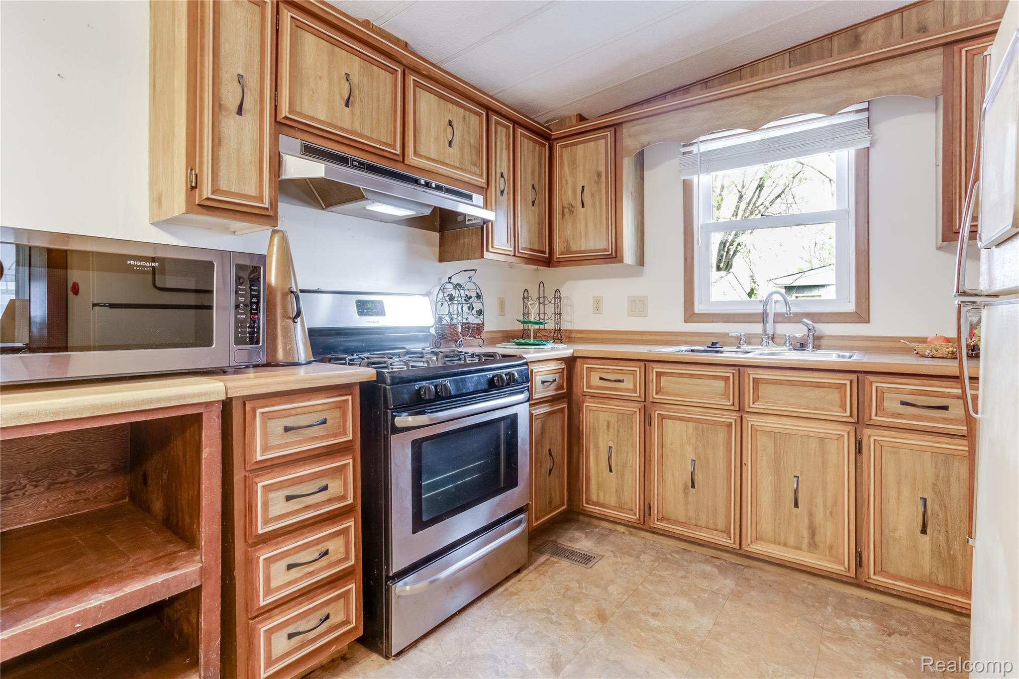 3333 Ravenswood Road Marysville, MI 48040 - Photo 6 of 25 Kitchen featuring stainless steel appliances, light countertops, and wood finish cabinets