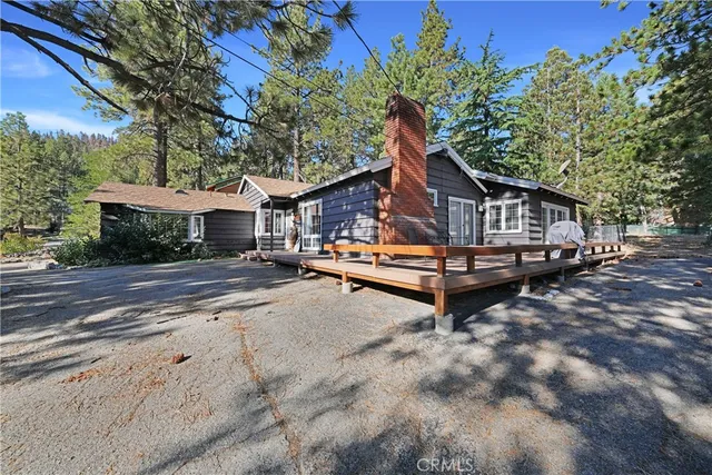 a view of a house with wooden deck and sitting area