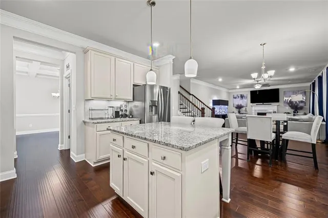 a kitchen with stainless steel appliances kitchen island granite countertop a white cabinets and wooden floor
