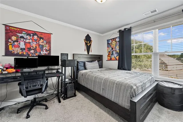 a bedroom with a bed a computer on the desk and chair