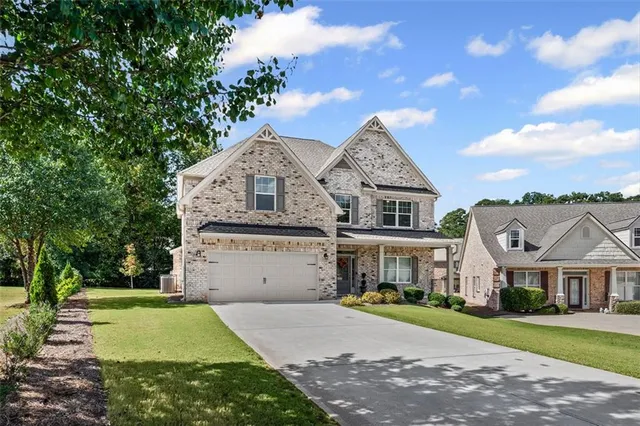 a front view of a house with a garden and trees