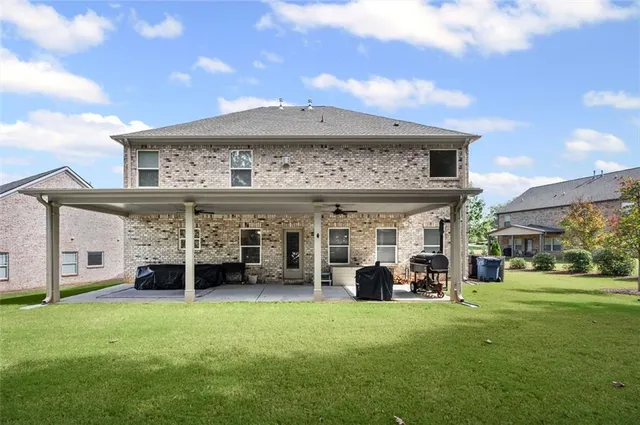 a view of a house with a big yard and large tree
