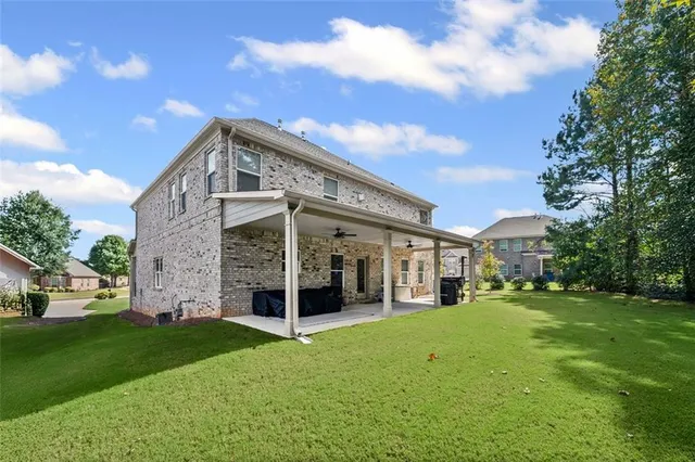 a view of a house with a yard and sitting area