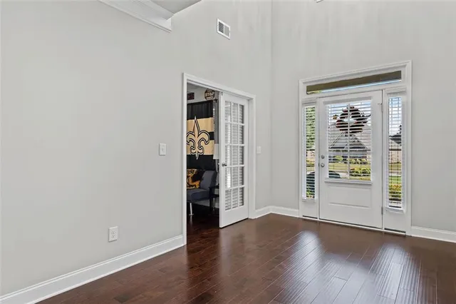 an empty room with wooden floor and entrance
