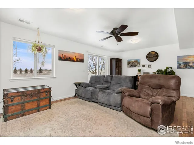 a living room with furniture and a ceiling fan