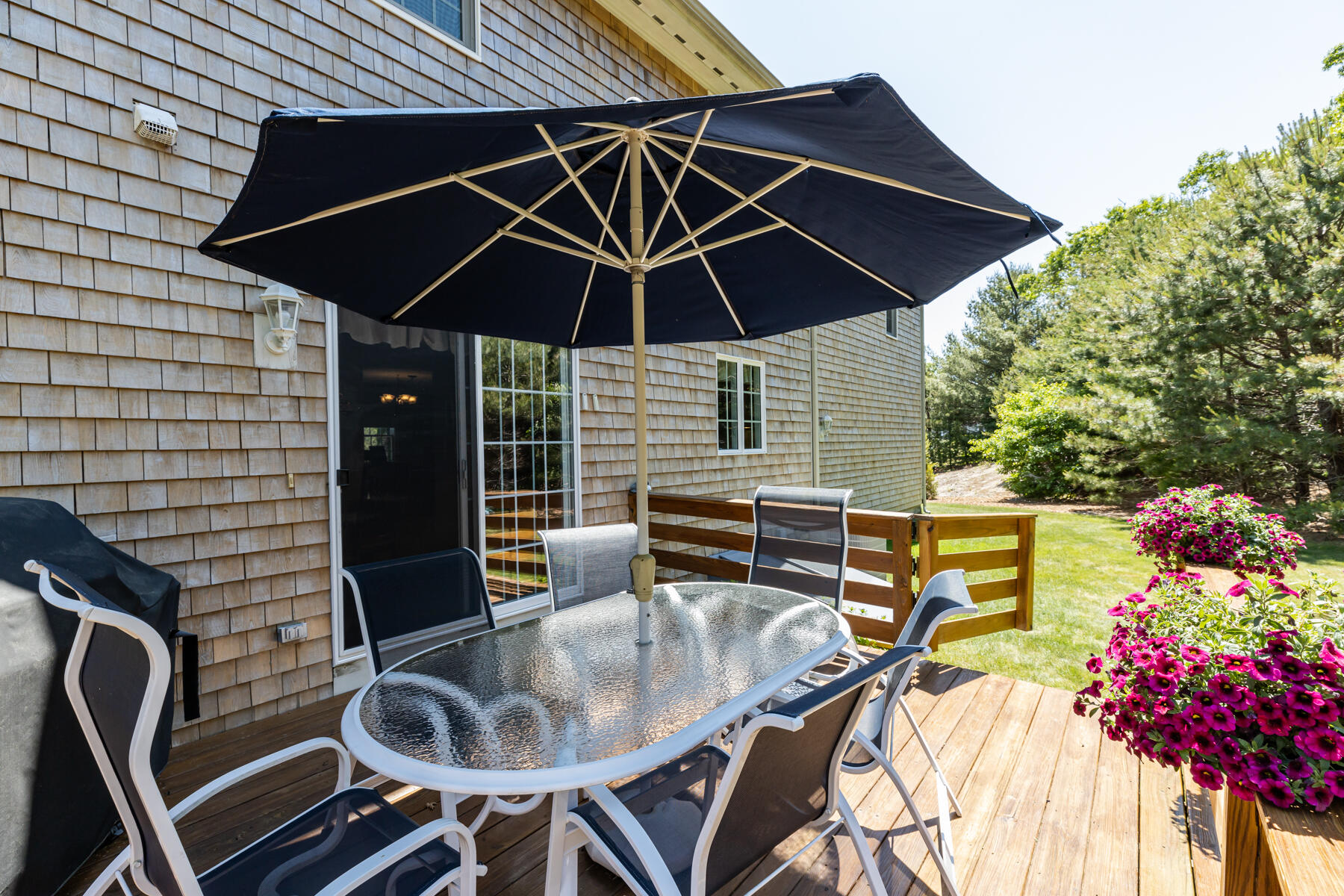 16 Tiffany Road Monument Beach, MA 02532 - Photo 31 of 42 a patio with a table and chairs under an umbrella
