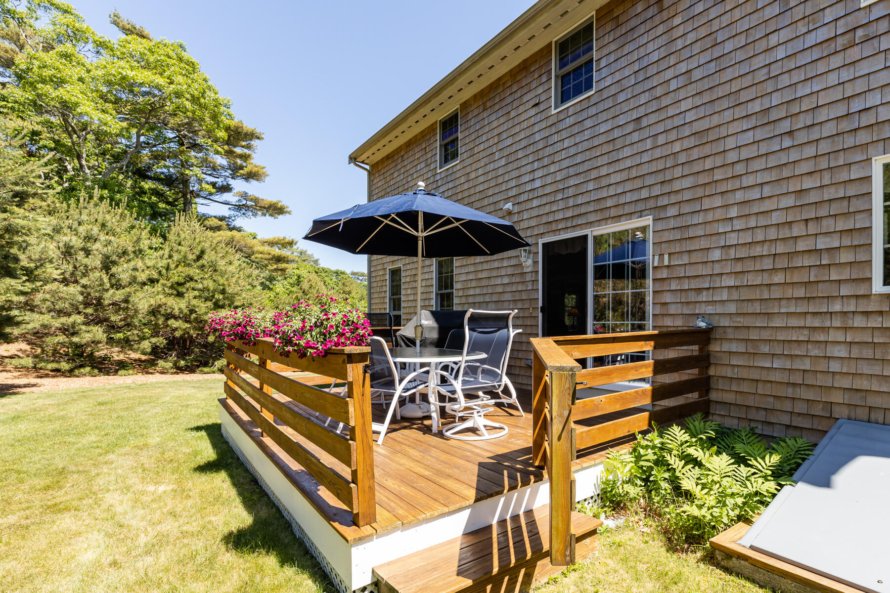 16 Tiffany Road Monument Beach, MA 02532 - Photo 32 of 42 a view of a patio with a table and chairs under an umbrella