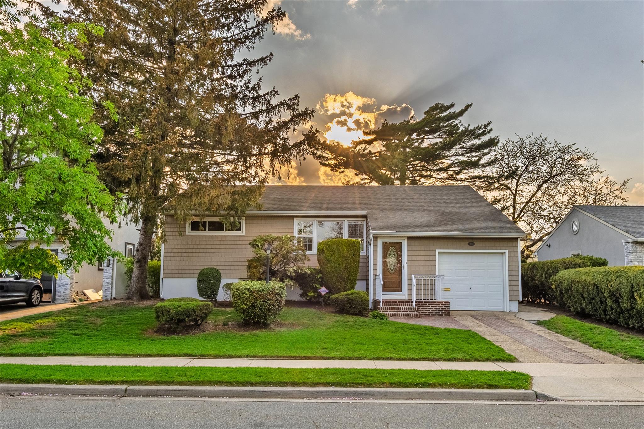 a front view of a house with a yard and potted plants