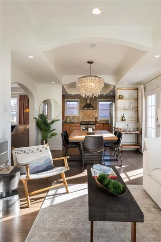 a living room with furniture a chandelier and a table