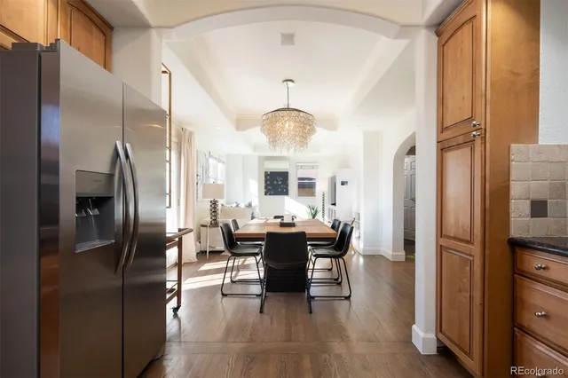 a dining room with furniture a chandelier and wooden floor