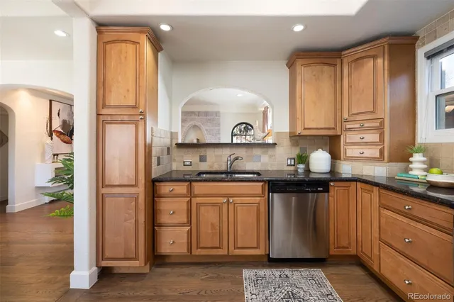 a kitchen with stainless steel appliances granite countertop a stove a sink and a refrigerator
