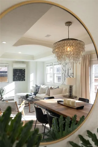 a living room with a table or chandelier and a dining table