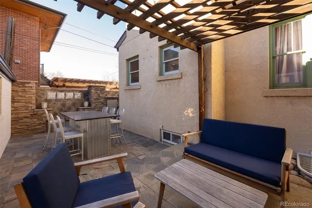 a view of a patio with table and chairs with wooden floor and fence