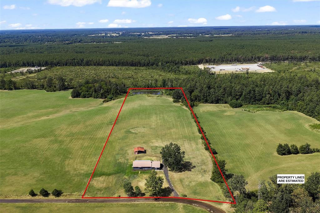 1131 Speights Road Keatchie, LA 71046 - Photo 3 of 33 Expansive land parcel featuring a residential structure, secondary outbuilding, and a private pond