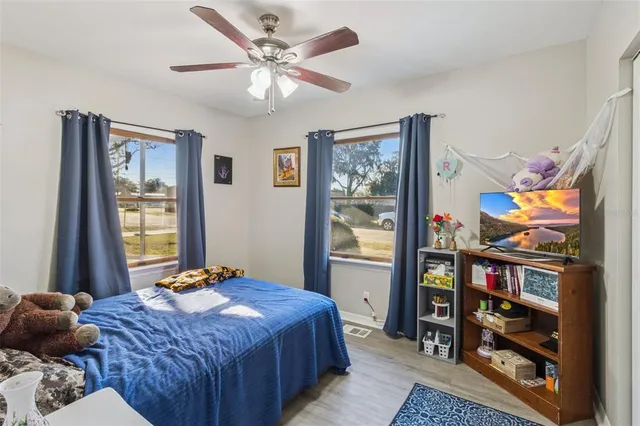 a bedroom with a bed a book shelf and a window
