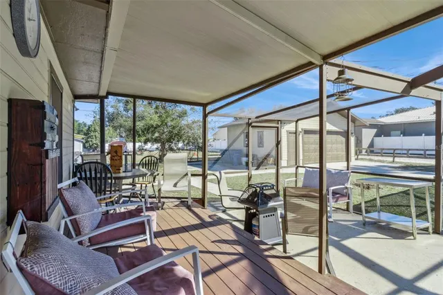 a patio with yard a table and chairs