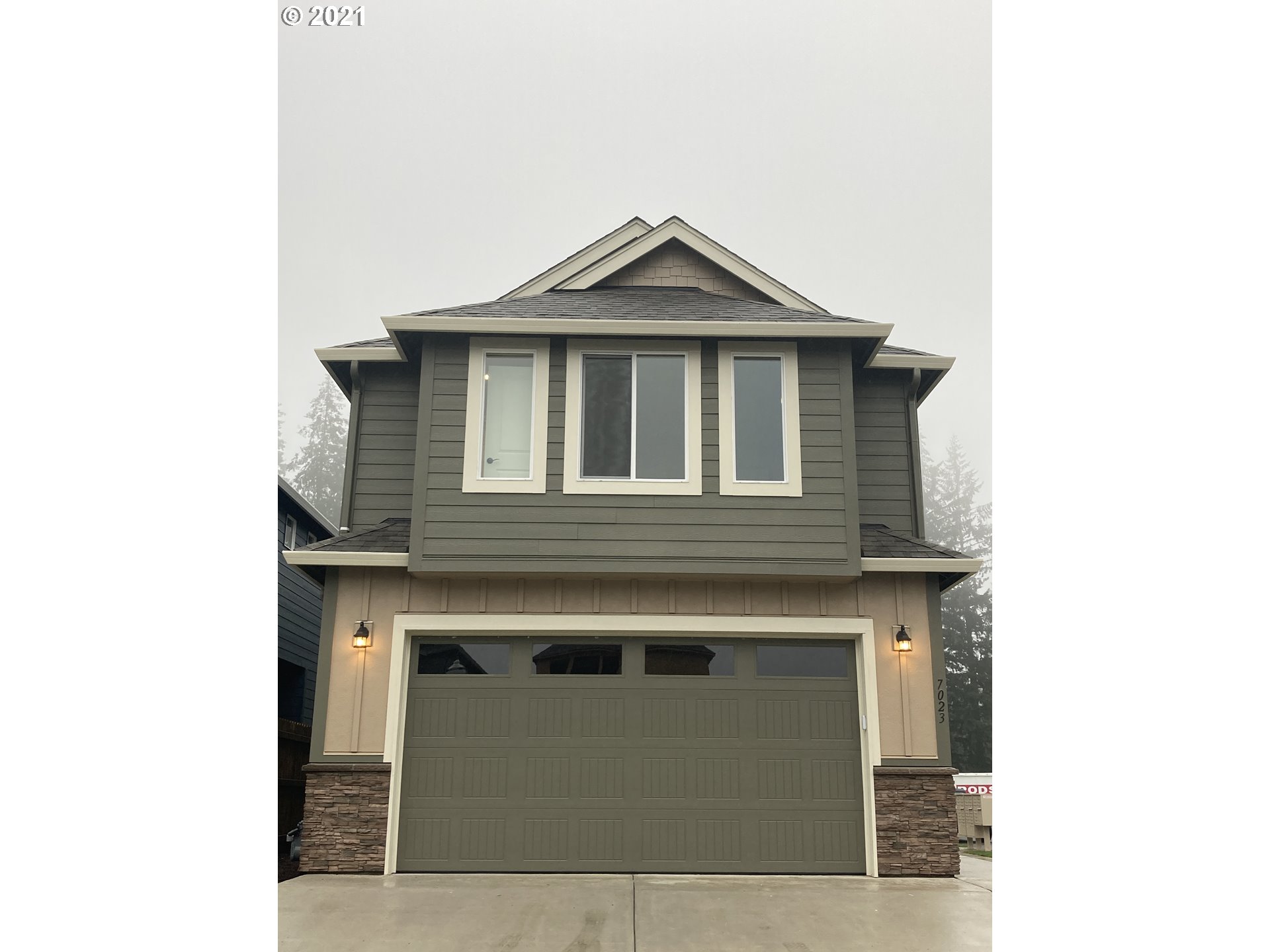 7023 South Ridge Way Ridgefield, WA 98642 - Photo 1 of 13 a front view of a house with a garage