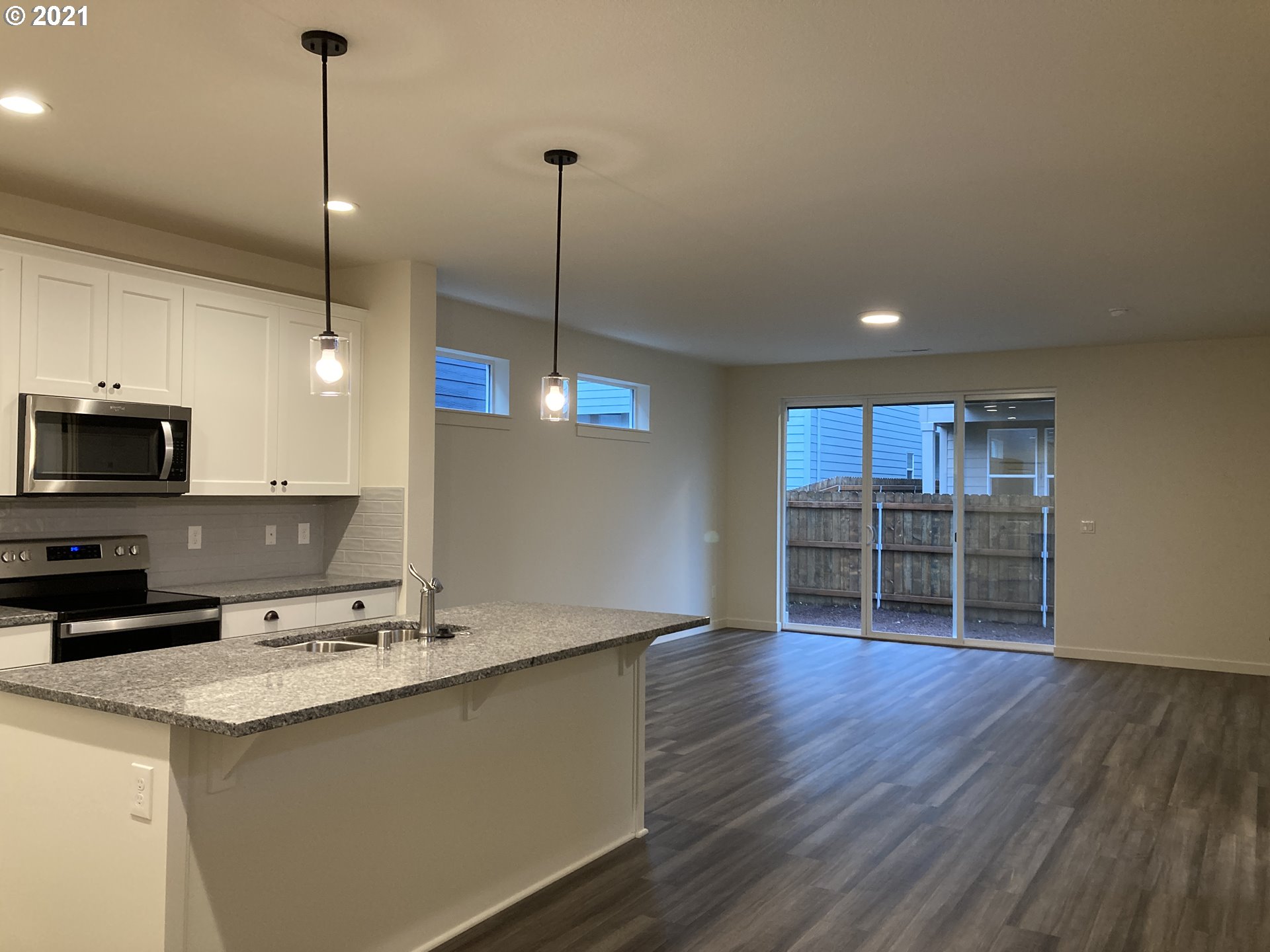 7023 South Ridge Way Ridgefield, WA 98642 - Photo 2 of 13 a kitchen with stainless steel appliances granite countertop a sink a refrigerator a stove and a wooden floor