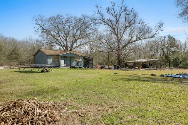 a view of a house with a yard and sitting area