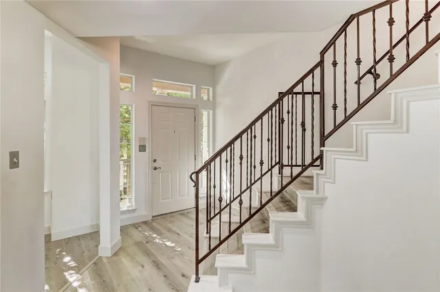 a view of staircase with wooden floor and white walls