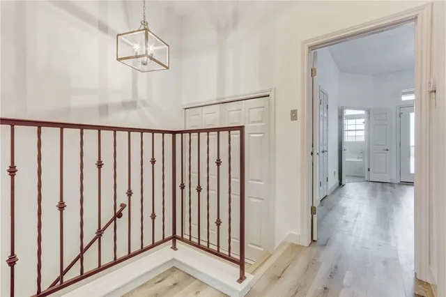 a view of a hallway with wooden floor and staircase