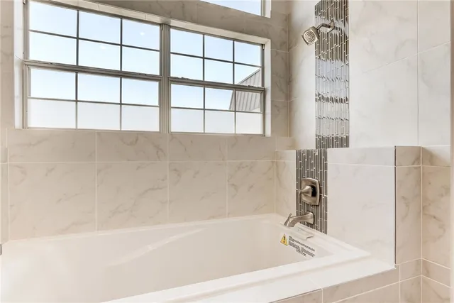 a bathroom with a bathtub and next to a window