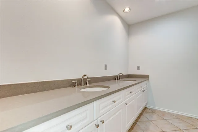 a bathroom with a granite countertop sink and white cabinets