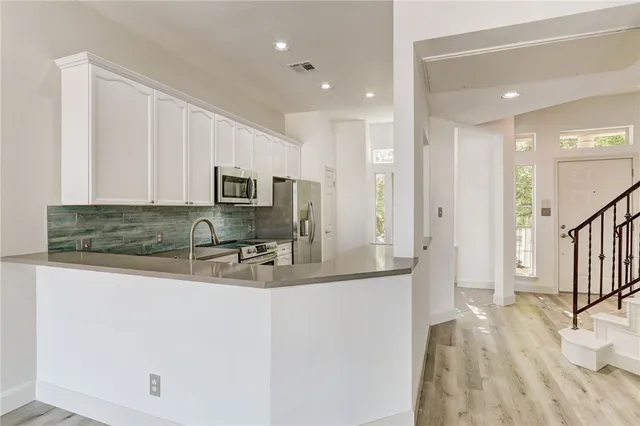 a kitchen with stainless steel appliances granite countertop a sink a stove and a refrigerator