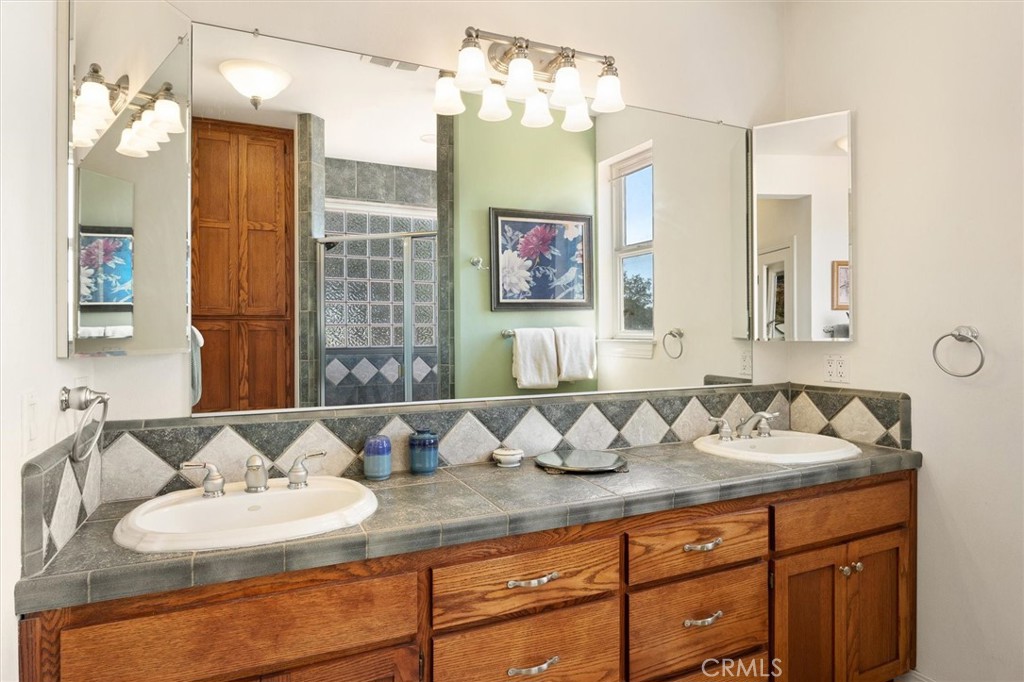 5625 Linne Road Paso Robles, CA 93446 - Photo 41 of 75 a bathroom with a granite countertop sink a mirror and shower