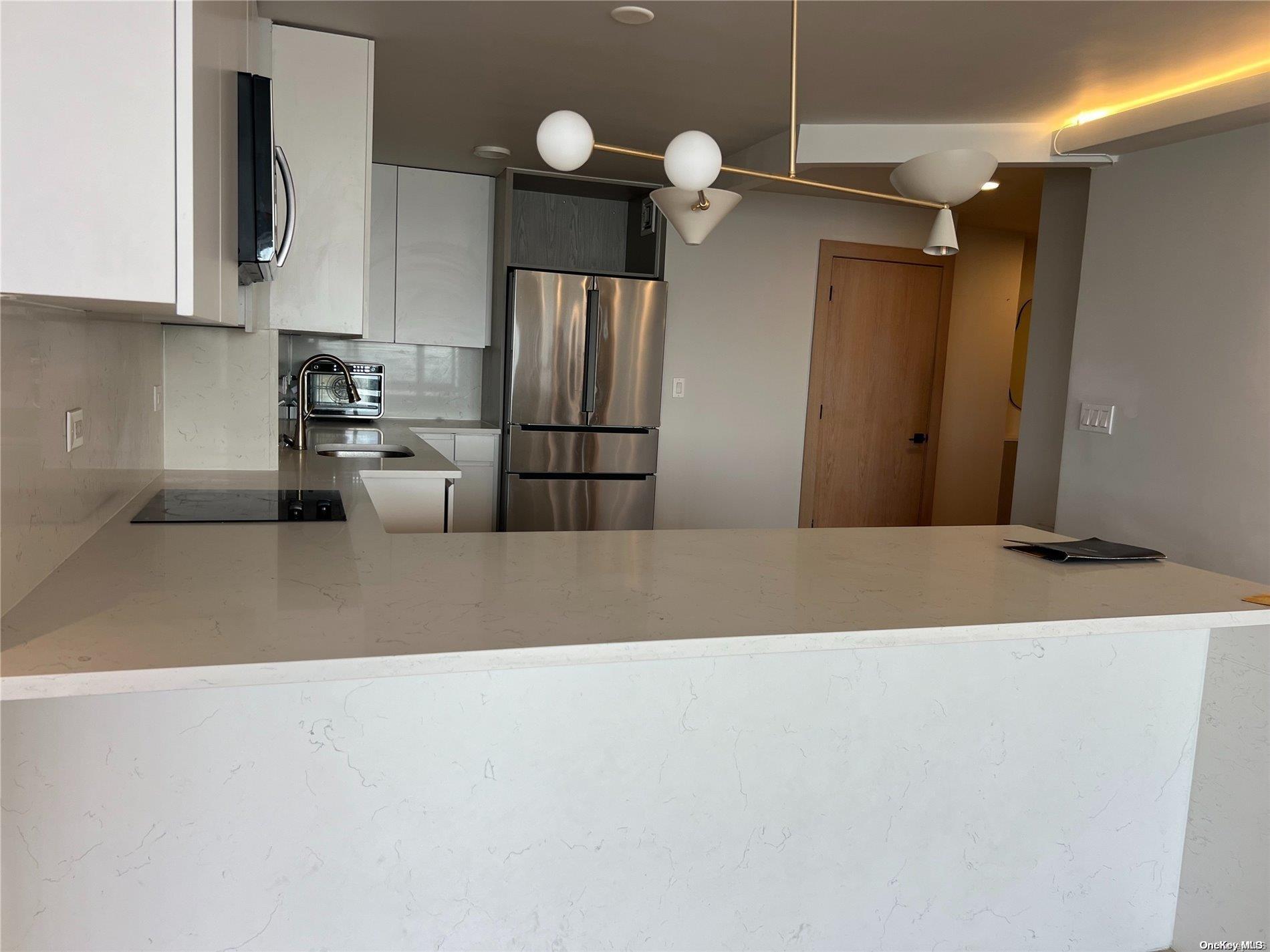 200 Rector Place, Unit 35E Manhattan, NY 10280 - Photo 12 of 33 a kitchen with refrigerator and cabinets