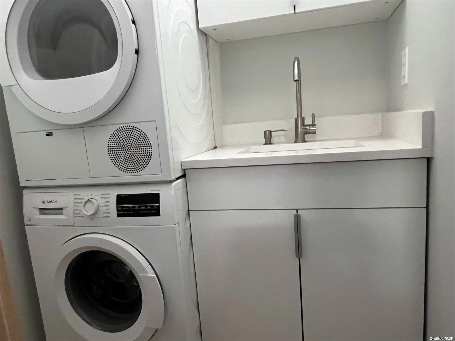 200 Rector Place, Unit 35E Manhattan, NY 10280 - Photo 22 of 33 a bathroom with a sink mirror a washer and dryer