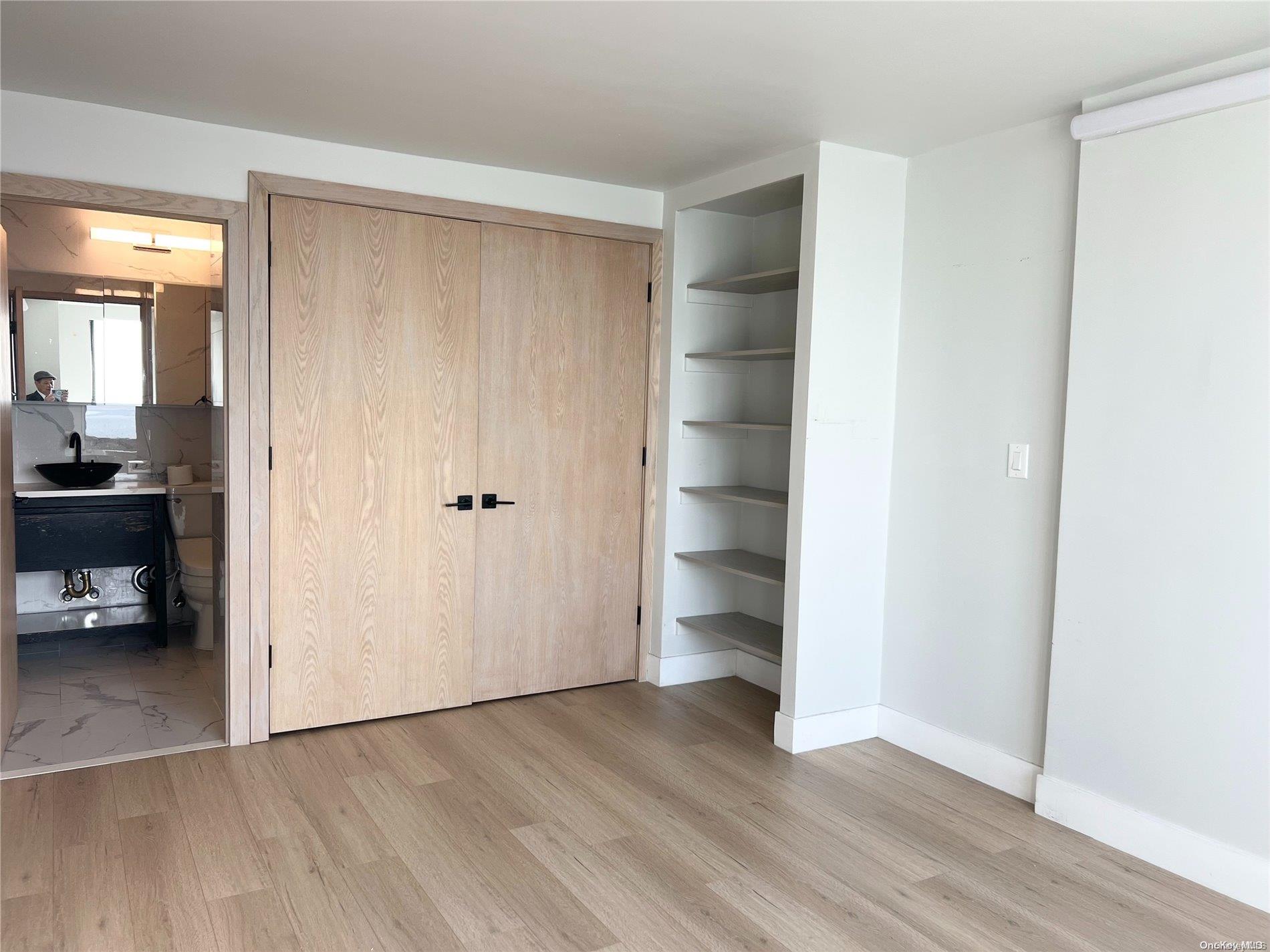 200 Rector Place, Unit 35E Manhattan, NY 10280 - Photo 4 of 33 an empty room with wooden floor and windows