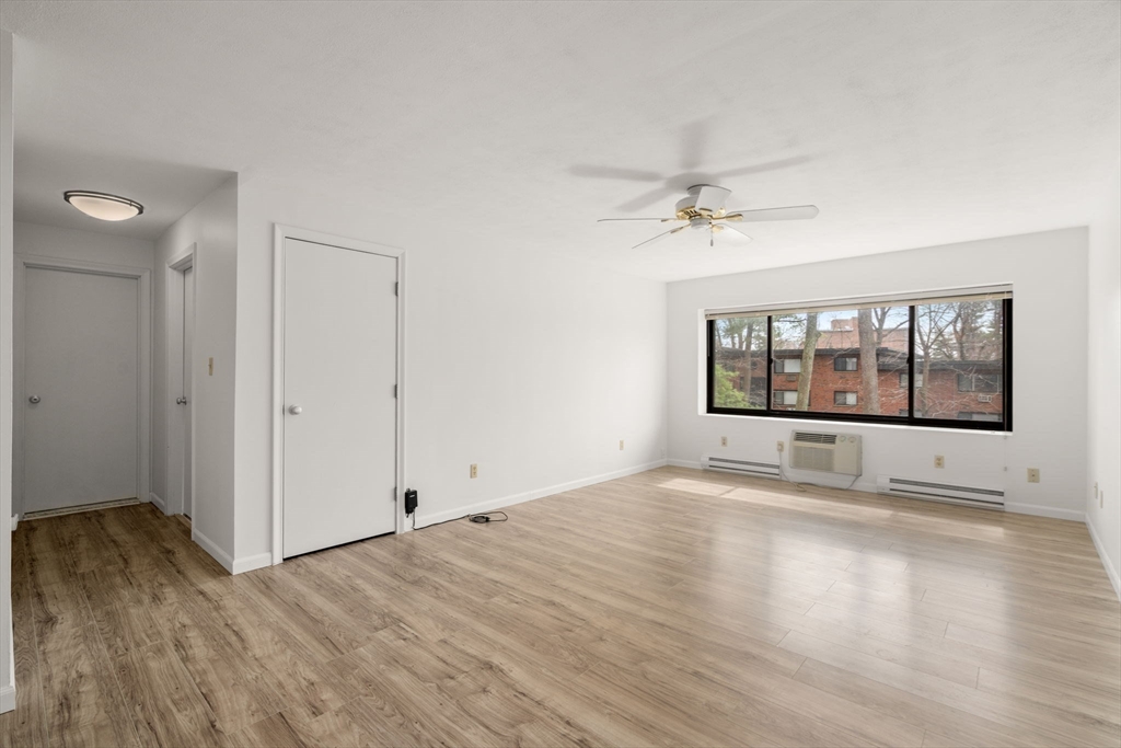 1325 Worcester Road, Unit A11 Framingham, MA 01701 - Photo 5 of 18 a view of an empty room with a window and wooden floor