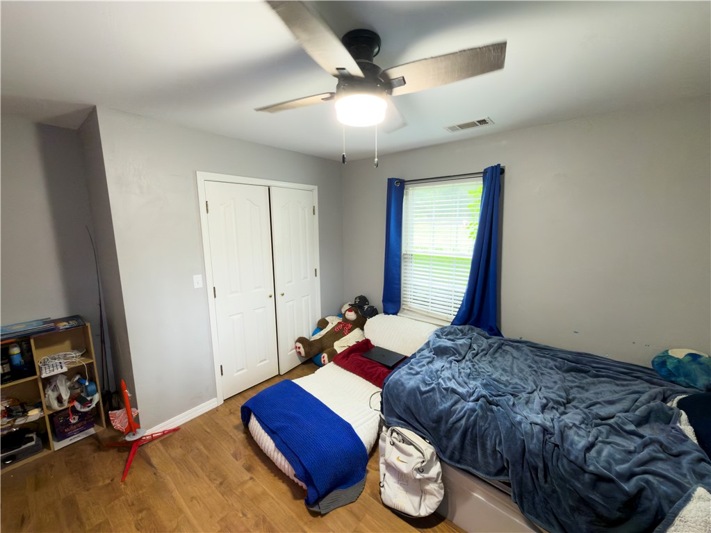 164 Park Road Russellville, AR 72802 - Photo 11 of 35 Room featuring wood-finish flooring, a ceiling fan with integrated lighting, a window with horizontal blinds, and bi-fold closet doors